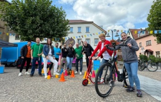 Teilnehmer des FeelGoodDay in Bad Sobernheim stehen mit Sportgeräten auf einem Stadtplatz